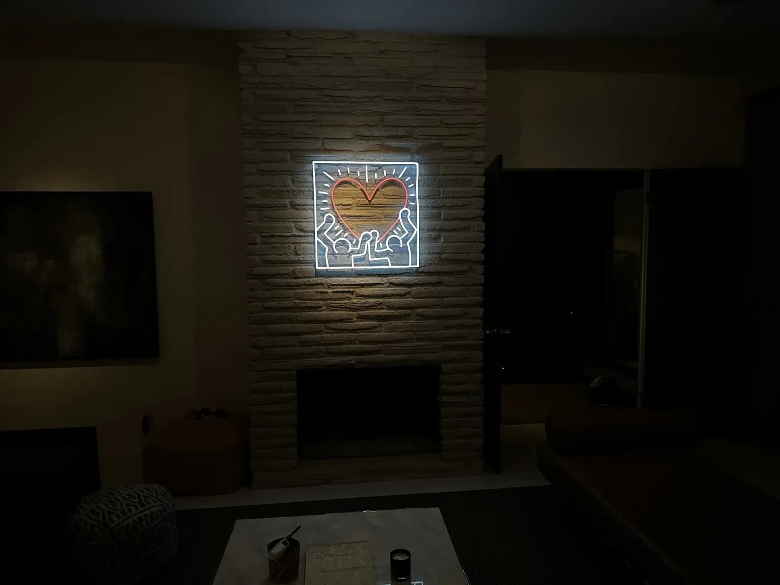 Neon heart light installed by TruLuxe Electric on a brick fireplace wall